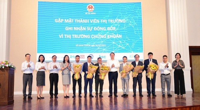 Thứ trưởng Nguyễn Đức Chi (thứ 6 từ trái sang) tặng hoa cảm ơn các thành viên thị trường ngày 28/7.